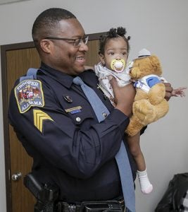 Alabama State Trooper Sgt. Donald R. Shepard Jr. gives a teddy bear to Trinity Hall Thursday at Vaughan Regional Medical Center.