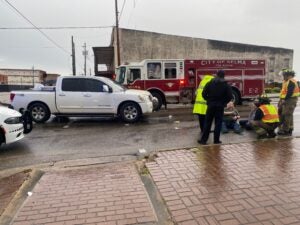 First responders care for two pedestrians who were hit by a pickup truck crossing Broad Street at the foot of the Edmund Pettus Bridge Tuesday morning.